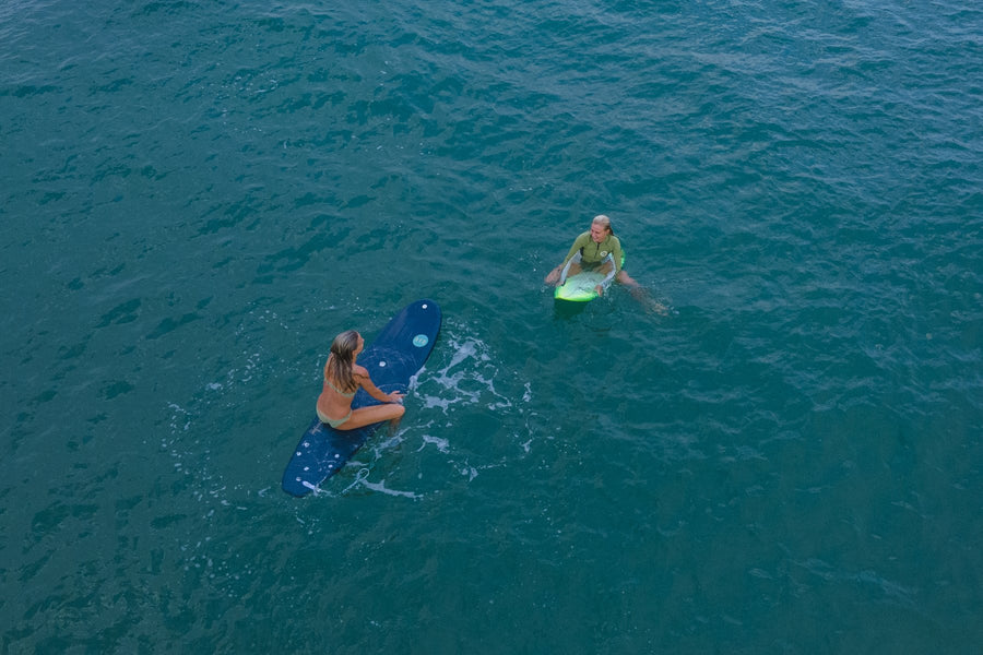 Woman surfer walking out to the water with her board