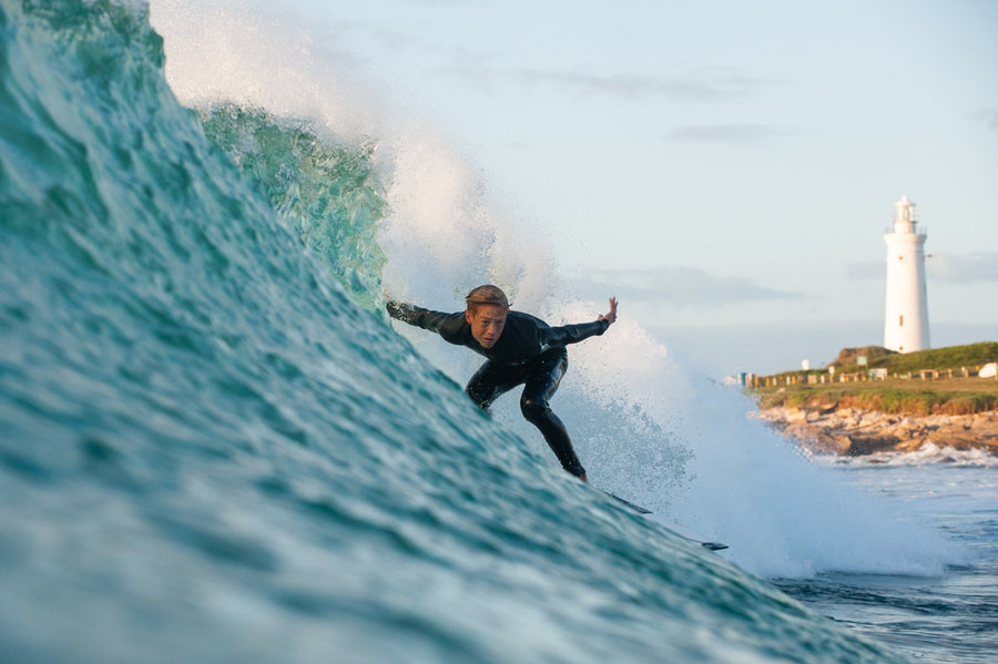 Young surfer carrying a shortboard along the beach